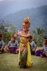 KABUL BULELENG, BALI, INDONESIA - 7 DE JUNIO DE 2018: Actuación al aire libre de la escuela de baile local, danza de niñas con disfraces, niños sentados en el fondo - foto de stock