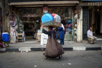 Egypt, Cairo Governorate, view of woman wearing on head basket at bazaar — Stock Photo