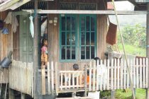 Indonesia, Kalimantan, Borneo, Kotawaringin Barat, Tanjung Puting National Park, niños en el balcón - foto de stock