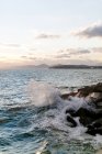 Grecia, Ática, Paleo Faliro, noche junto al mar, vista del Pireo desde la muralla del puerto y rompiendo olas - foto de stock