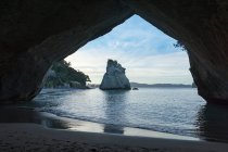 Nouvelle-Zélande, Waikato, péninsule de Coromandel, Cathedral Cove, Hahei, paysage marin pittoresque avec des rochers au bord de la côte depuis la grotte — Photo de stock