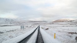 Diminishing perspective view of snowy road, Iceland — Stock Photo