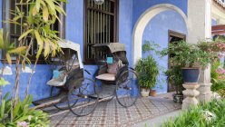 Rickshaws in courtyard of blue mansion, Pulau Pinang, Malaysia — Stock Photo
