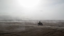 Індонезія, Джава Тимур, Проболінго, Людина на мотоциклі в тумані на Mt. Бромо — стокове фото