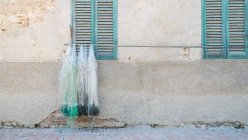 Італія, Умбрія, Ізола-Маджоре, Рибальські тенета на полюс на стіні будинку, Тразімено — стокове фото
