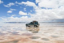 Bolivia, Departamento de Potosi, Nor Lopez, Jeep in the salt desert Uyuni at the rainy season — Stock Photo