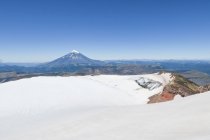 Чили, Quetrupillan Volcano top over snowy mountains landscape — стоковое фото