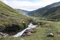 Perú, Cuzco, Lares, en la caminata de Lares a Machu Picchu, montañas verdes y arroyo - foto de stock