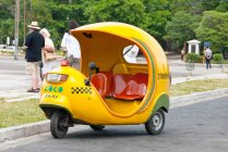 Kuba, Havanna, Blick auf das typische gelbe Coco-Taxi — Stockfoto