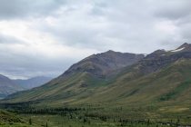 Канада, Юйфэньхэ, Юйфэньхэ, На дамбстерском шоссе, на фоне дикого северного ландшафта с горами под тяжелым небом — стоковое фото