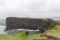 Scogliere verdi e mare sotto il cielo nuvoloso, Islanda — Foto stock