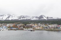 Argentina, Tierra del Fuego, Ushuaia, hacia la ciudad de Ushuhaia por el mar, montaña cubierta de nieve en el fondo - foto de stock