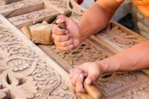 Uzbequistão, mãos masculinas decorando portas de madeira tradicionais — Fotografia de Stock