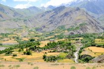 Tayikistán, pueblo afgano al otro lado del río Panj, vista de las montañas en el fondo - foto de stock
