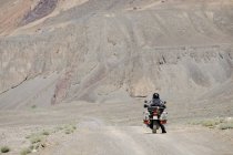 Tagikistan, uomo in moto nella valle laterale vicino Murghab — Foto stock