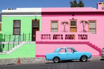 Sudáfrica, Cabo Occidental, Ciudad del Cabo, las coloridas casas de Bo-Kaap y un coche vintage azul brillante - foto de stock