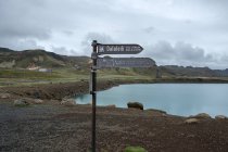 Austurrengjahver and green Lake Graenavatn arrow signs with landscape on background — Stock Photo