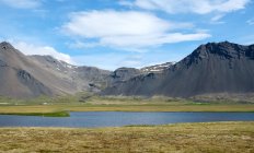 Sole illuminato paesaggio con montagne e lago, Islanda — Foto stock