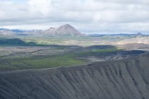 Part of crater Hverfjall and mountainous landscape under cloudy sky, Iceland — Stock Photo