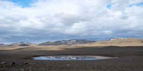 Vista del paisaje del cielo azul y las montañas que se reflejan en la piscina, Islandia - foto de stock