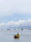 Аргентина, Огненная Земля, Ушуайя, лодки в воде, облака над морем на заднем плане — стоковое фото