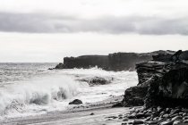 USA, Hawaii, Mare con onde che si infrangono su rocce di lava sulla spiaggia di Kalapana — Foto stock
