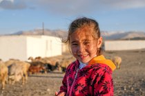 Asiatisches Mädchen lächelt winkend mit der Hand in die Kamera, Tadschikistan — Stockfoto