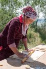 Femme cuisson pâte à la cuisine extérieure, Ak Say, Issyk-Kul région, Kirghizistan — Photo de stock