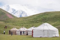 Kirguistán, región de Osh, campo de yurtas con el monte Lenin al fondo - foto de stock