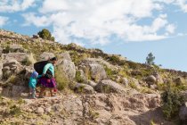 Mutter und kleines Mädchen zu Fuß auf Landstraße, Puno, Peru — Stockfoto