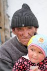 Portrait of Grandpa with granddaughter at village street in Tajikistan — Stock Photo