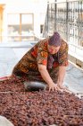 Mujer adulta desplegando frutas para secar, Uzbekistán - foto de stock