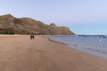 Spain, Canary Islands, Tenerife, walk in the evening by beach of Playa de Las Teresitas — Stock Photo