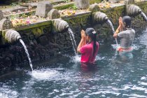 Indonésia, Bali, Gianyar, Orando mulheres na água do templo hindu Pura Tirta Empul — Fotografia de Stock