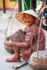 Vieja con sombrero cónico riéndose de la cámara, Vietnam - foto de stock