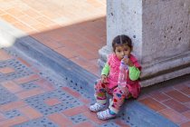 Retrato de menina com garrafa de plástico sentado no degrau, Arequipa, Peru — Fotografia de Stock