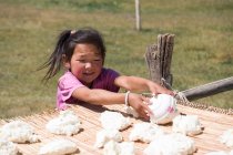 Kirguistán, región de Naryn, niña en la producción de queso crema - foto de stock