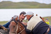 OSH REGION, KYRGYZSTAN - JULY 22, 2017: Men wrestling on horseback during nomad games — Stock Photo