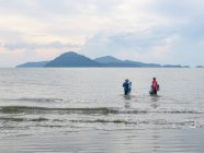 Tailandia, Chang Wat Phang-nga, Tambon Khuekkhak, pescadores en Phang Nga, pesca tradicional en la playa, montañas en el fondo - foto de stock