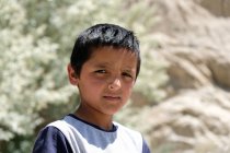 Ritratto del ragazzo rurale che guarda la telecamera sulla strada, Tagikistan — Foto stock