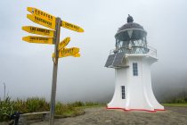 New Zealand, Northland, Cape Reinga, Lighthouse at Cape Reinga and yellow directions signs in foggy weather — Stock Photo