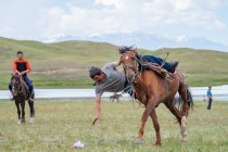 REGIONE OSH, KYRGYZSTAN - 22 LUGLIO 2017: Nomadgames, uomo a cavallo e pratica esercizio di abilità al galoppo, montagna sullo sfondo — Foto stock