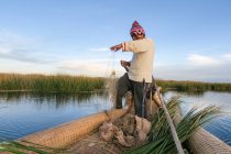 Homme local pêche traditionnellement sur le bateau à Puno, Pérou . — Photo de stock