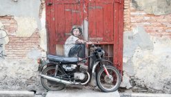 Malasia, Pulau Pinang, Georgetown, Arte urbano en Penang con bicicleta aparcada cerca de la pared - foto de stock