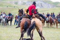 OSH REGION, KYRGYZSTAN - 22 июля 2017: Кочевые игры, мужчины соревнуются на лошадях, участники козьего поло — стоковое фото