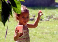 Дівчина Самоа, Salua, дивлячись atcamera та проведення напій з футболу — стокове фото