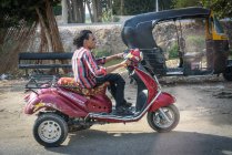 Vista lateral del hombre en motocicleta conduce más allá de motor-rickshaw, Sakkara, Cairo Governorate, Egipto - foto de stock