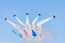 Reino Unido, Escócia, East Lothian, North Berwick, Red Arrows no show anual Scotlands National Airshow em East Fortune, realizando aeronaves no céu deixando contrails coloridos, vista de fundo — Fotografia de Stock
