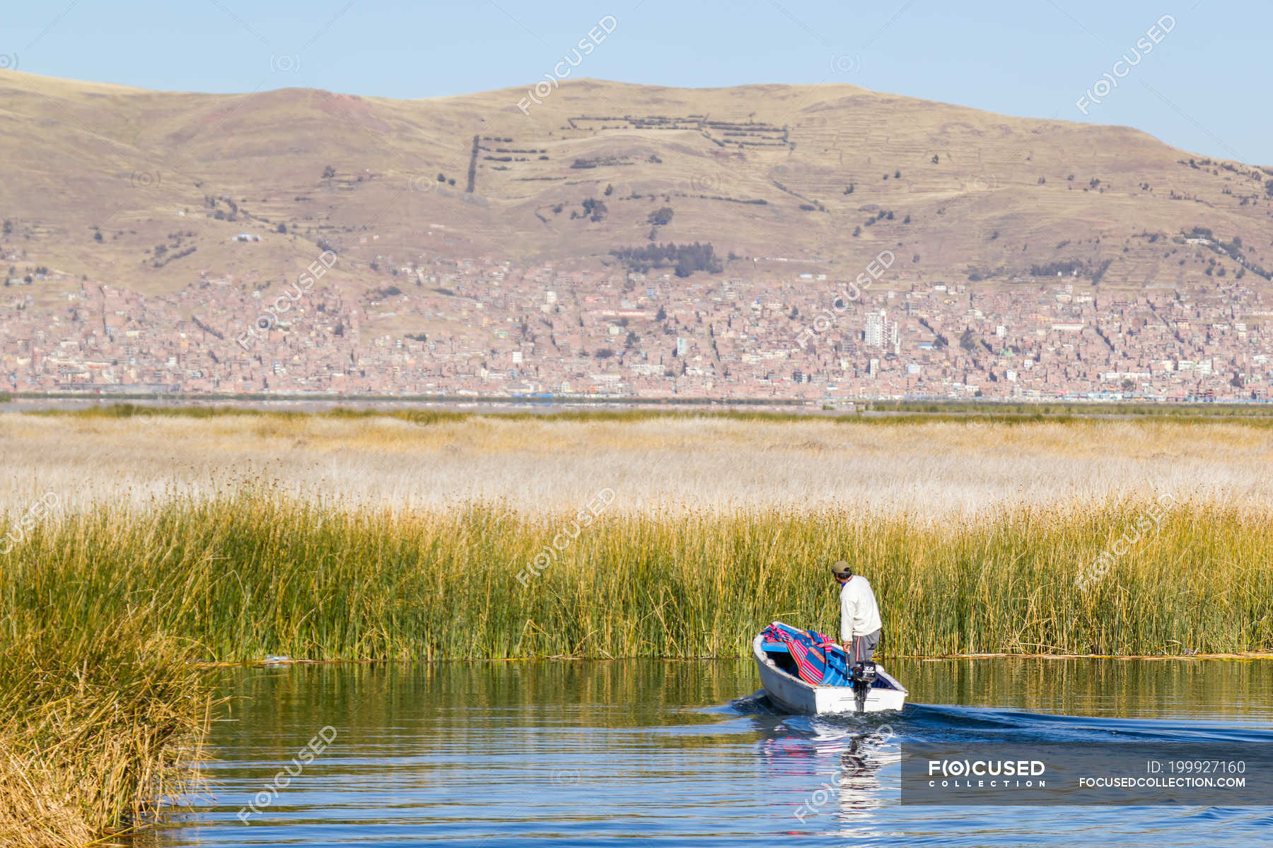 Peru, Puno, Puno, man in boat on Lake Titikaka - Uros Island — america