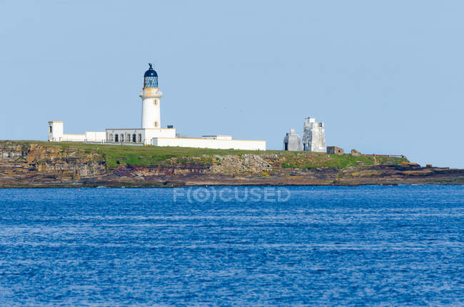 Великобритания, Шотландия, Оркнейские острова, живописный морской пейзаж с белым маяком — стоковое фото